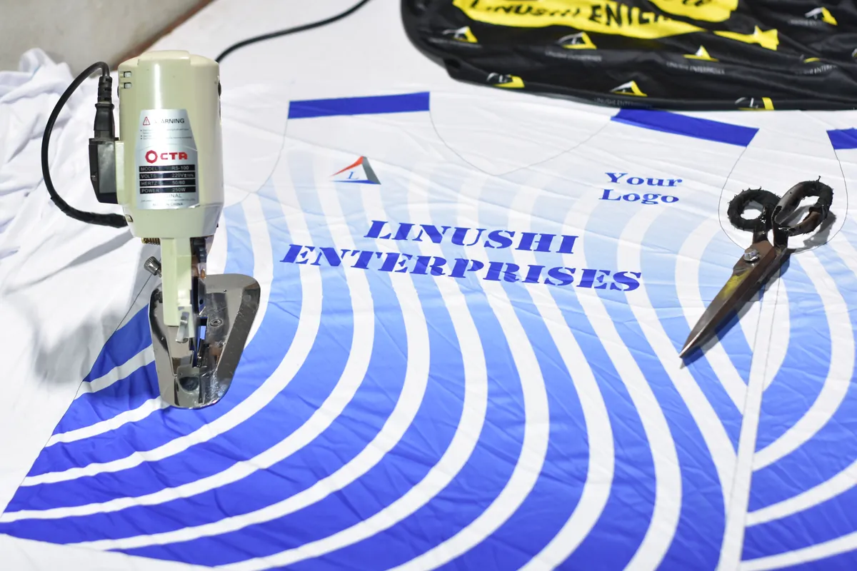 Custom sportswear fabric being cut on a cutting machine at the Linushi sportswear manufacturer facility