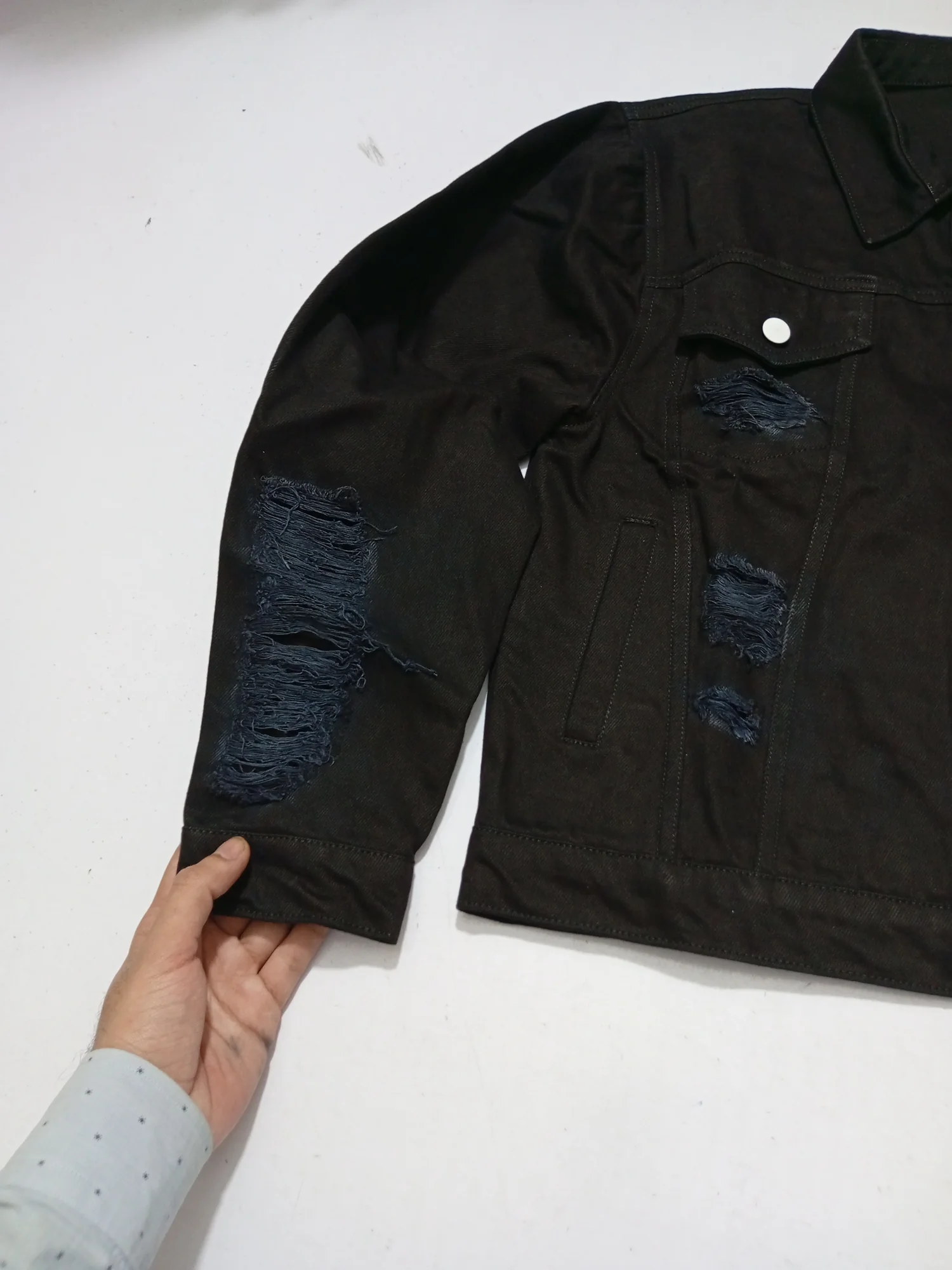 Black distressed denim jacket, front