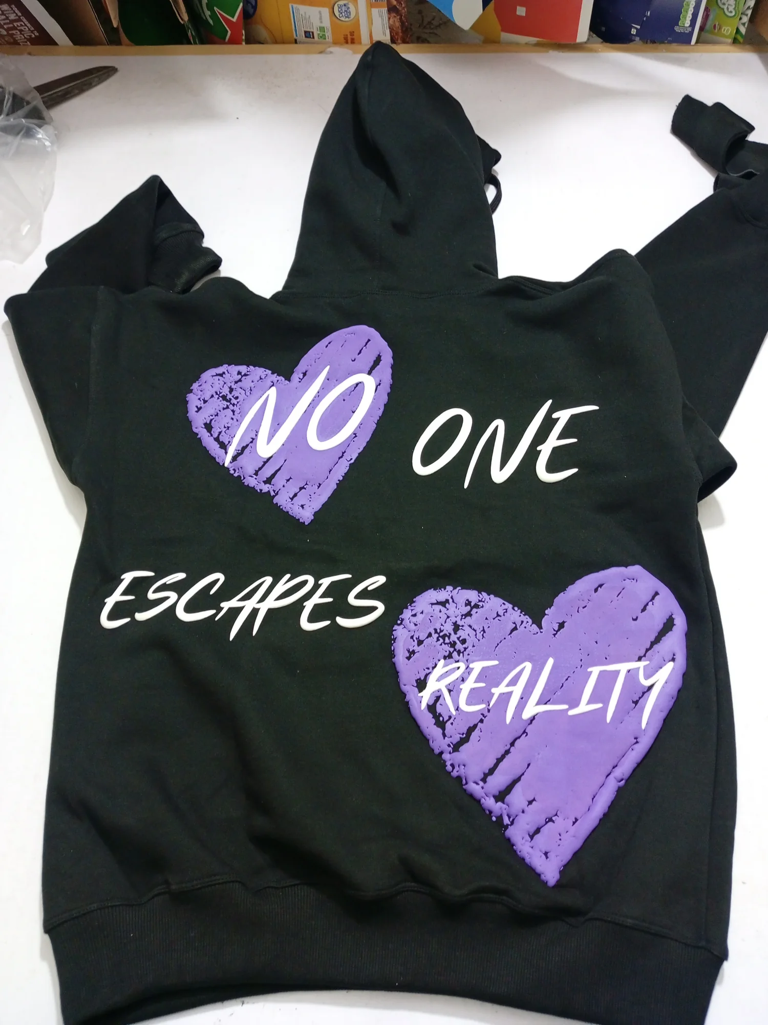 Black hoodie with large puff print hearts on the back