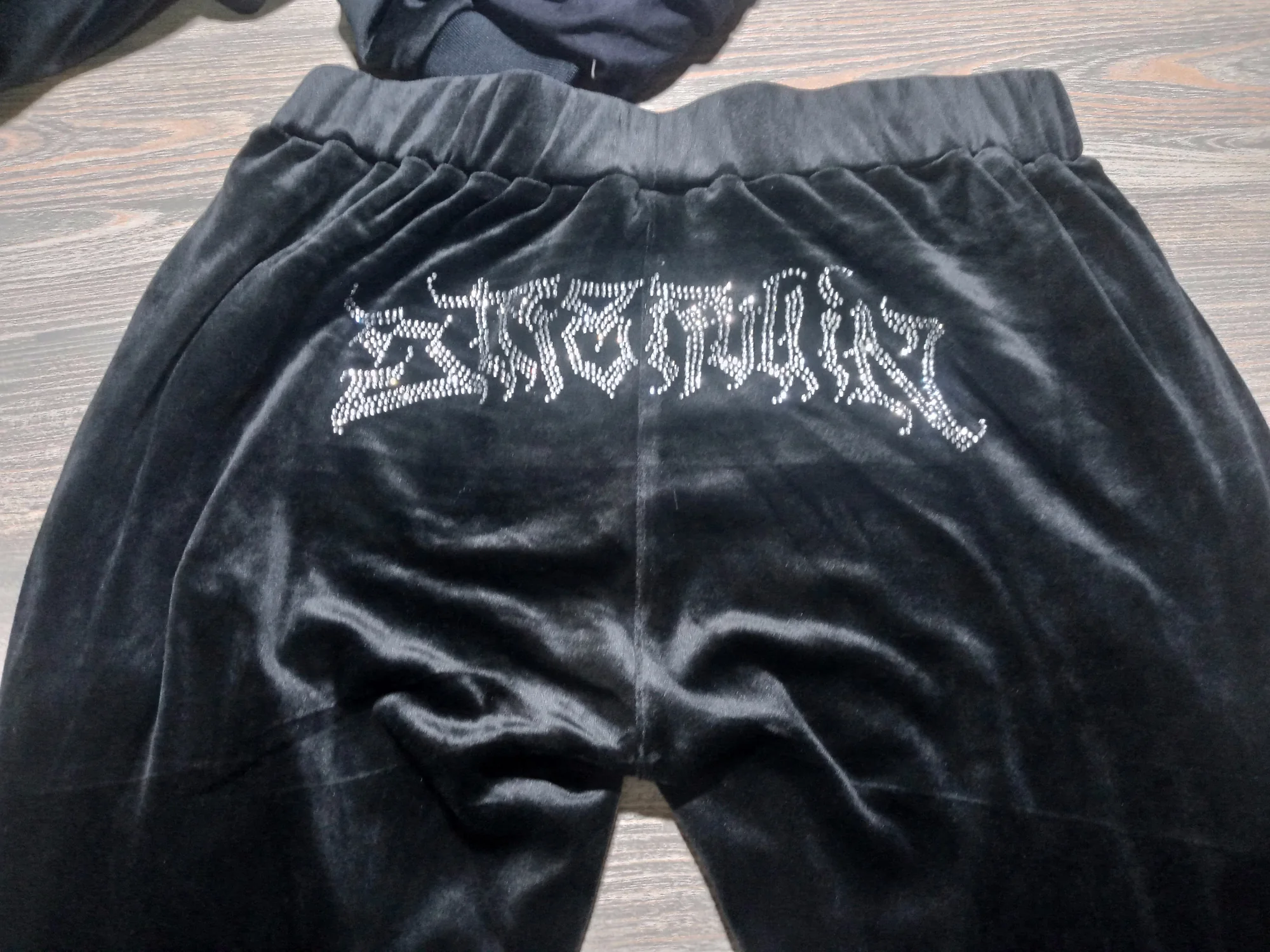 Black velour pants with rhinestone lettering on the back