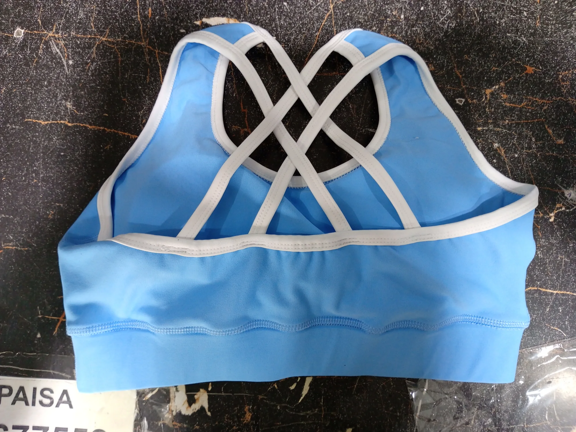 Blue sports bra with white binding on the cross straps