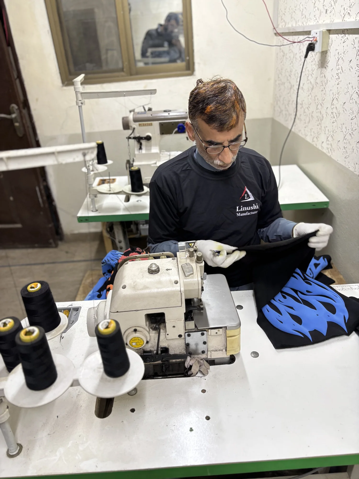 Tailor overlock stitching a printed hoodie at Linushi