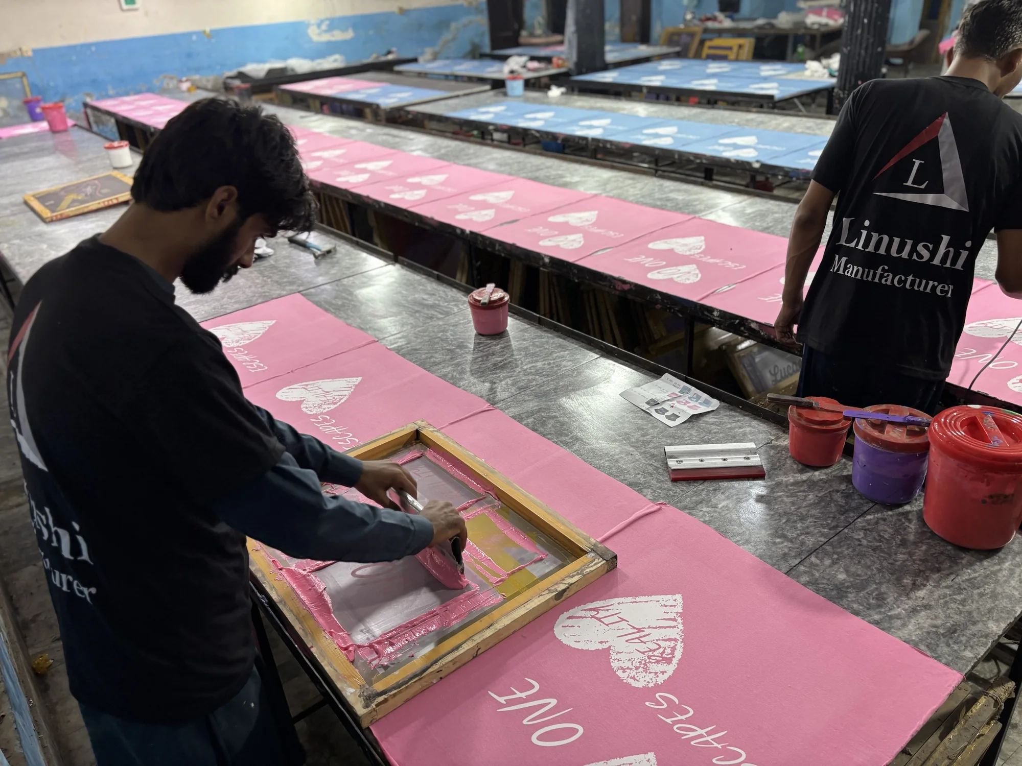 Screen printing pink t-shirts for a bulk order at Linushi