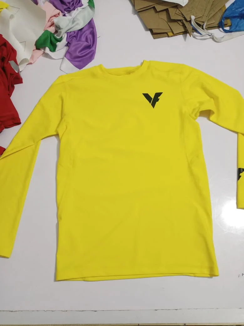 Yellow custom rash guard with printed logo, laid flat